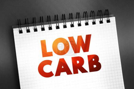 Foto de Bajo en carbohidratos - dieta significa que usted come menos carbohidratos y una mayor proporción de proteínas y grasas, concepto de texto en el bloc de notas - Imagen libre de derechos