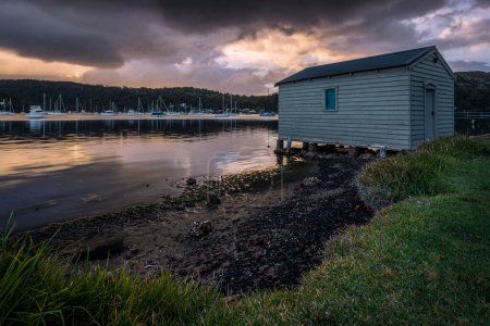 Foto de Casa del barco y la hierba al amanecer en Wagstaffe en NSW Escudo Central con agua - Imagen libre de derechos