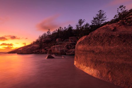 a sunset over a body of water on magnetic island in australia
