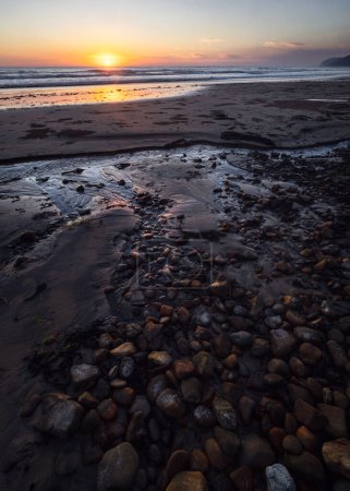 Téléchargez les photos : Galets dans le ruisseau sur la plage au lever du soleil Minnie Water Côte nord-ouest de l'Australie - en image libre de droit