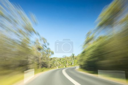 Téléchargez les photos : Photo longue exposition de voiture conduisant sur la route avec des arbres flous passant par - en image libre de droit