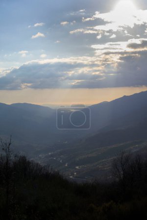 Photo for Vertical view of Valle del Jerte at sunset in winter with sun between clouds - Royalty Free Image