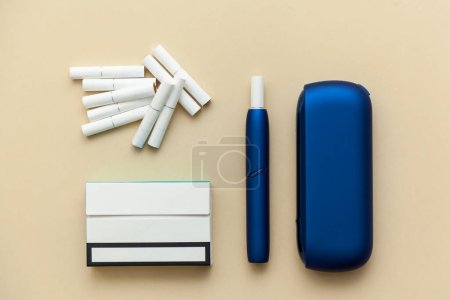 Photo for Electronic blue IQOS cigarette, with box with cigarettes on a beige background. - Royalty Free Image