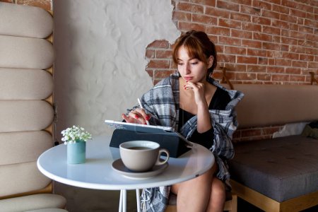 Photo for A girl in a cafe draws with a stylus on a graphics tablet.Remote work of a designer, visualizer or artist - Royalty Free Image