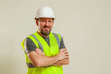 A guy in a white construction helmet, a gray T-shirt shows different gestures with his hands