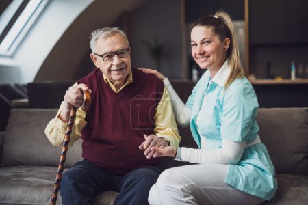 Photo for Nurse home caregiver is assisting old man at his home. Professional health support for elderly people. - Royalty Free Image
