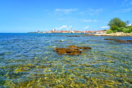 Téléchargez les photos : Vue panoramique de la vieille ville d'Umag, littoral adriatique, Istrie, Croatie. Paysage estival avec architecture médiévale, eau de mer bleue claire et ciel avec nuages, arrière-plan de voyage en plein air - en image libre de droit