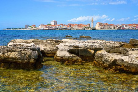 Téléchargez les photos : Vue panoramique de la vieille ville d'Umag, littoral adriatique, Istrie, Croatie. Paysage estival avec architecture médiévale, eau de mer bleue claire et ciel avec nuages, arrière-plan de voyage en plein air - en image libre de droit