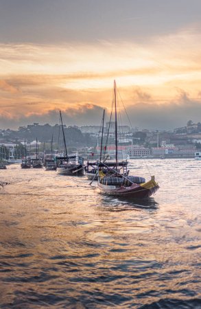 Photo for Sunset in the Douro, typical Porto boats known as "rabelos", Porto. Portugal - Royalty Free Image