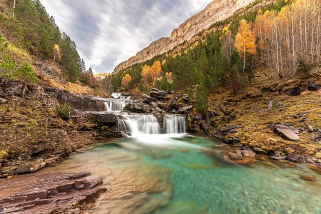 The magic of the autumn landscape of Monte Perdido, the Las Gradas de Soaso Waterfall is located in the Valley of the Arazas River, in the Ordesa y Monte Perdido National Park.