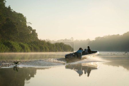 Foto de Excursión en bote de observación de vida silvestre durante el amanecer en el río Kinabatangan a lo largo de un exuberante bosque en Sukau, Sabah, Borneo, Malasia - Imagen libre de derechos