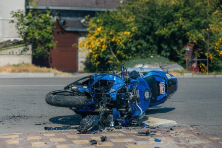 Foto de La motocicleta se encuentra en el pavimento después de un accidente de tráfico. La motocicleta dañada yacía en la carretera pavimentada. Accidente grave. - Imagen libre de derechos