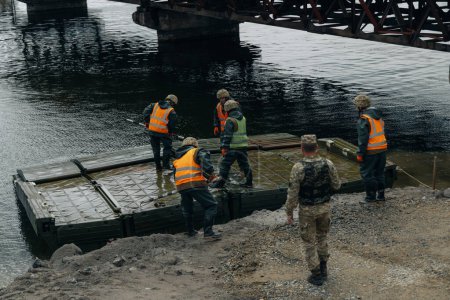 Téléchargez les photos : Pont de Ponton de l'armée ukrainienne. Installation d'un passage temporaire près du pont détruit. Soldats collectionnent ponton ferry. DNIPRO, Nikopol 26 mai 2020 - en image libre de droit