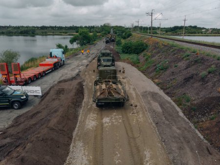 Téléchargez les photos : Pont de Ponton de l'armée ukrainienne. Installation d'un passage temporaire près du pont détruit. Soldats collectionnent ponton ferry. Vue de dessus depuis un drone. Nikopol, UKRAINE 26 mai 2020 - en image libre de droit