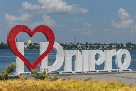 Instalación "I LOVE DNIPRO" en el terraplén de Sicheslavskaya. Corazón rojo y texto blanco sobre fondo de agua azul. La ciudad de Dnipro, Ucrania.