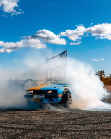Photo for A racing car drifts on a fast track. The driver drifts the car. A car skidding against a background of smoke, smoking wheels. Speed. Extremesport. Route. DNIPRO, UKRAINE - November 30, 2023 - Royalty Free Image