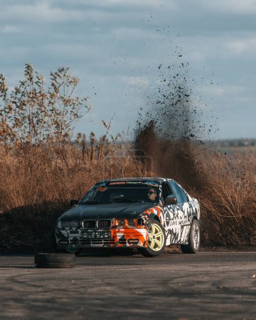 Photo for A racing car drifts on a fast track. The driver drifts the car. A car skidding against a background of smoke, smoking wheels. Speed. Extremesport. Route. DNIPRO, UKRAINE - November 30, 2023 - Royalty Free Image