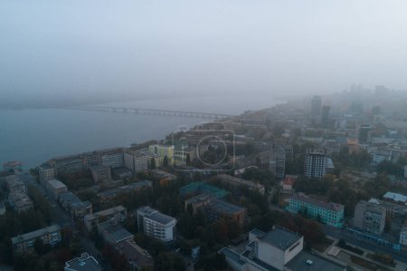 Téléchargez les photos : Vue aérienne de la ville de Dnipto, Ukraine dans le brouillard. Paysage urbain. Vue panoramique. Foggy metropolis. Ville fantôme. Coup de feu atmosphérique. - en image libre de droit