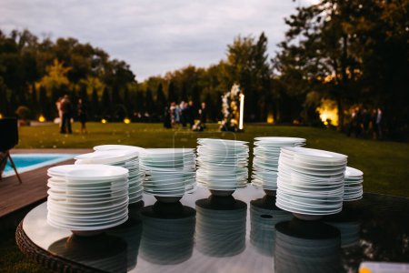 Téléchargez les photos : Des piles de assiettes blanches vides propres lors d'une fête. - en image libre de droit