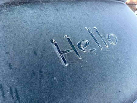 Téléchargez les photos : Bonjour mot écrit à la main sur une fenêtre de voiture gelée. - en image libre de droit