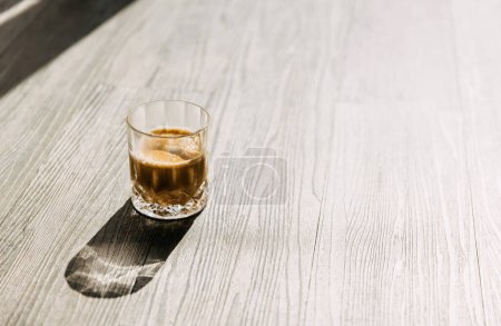 Téléchargez les photos : Tasse de café sur un plancher de bois dans la lumière du soleil du matin. - en image libre de droit