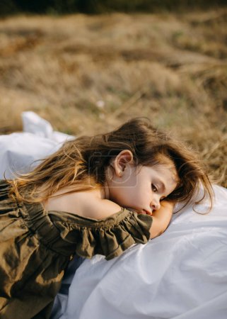 Photo for Sad little girl lying on her mothers laps outdoors. - Royalty Free Image