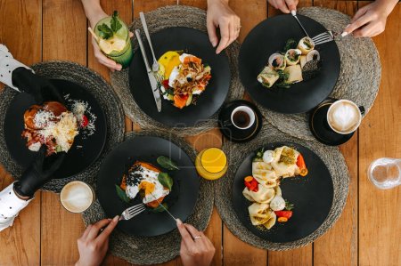 Photo for Overhead view of a brunch spread with diverse dishes and drinks on a wooden table. - Royalty Free Image