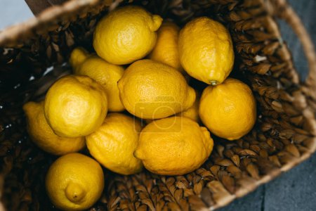 Foto de Limones brillantes enclavados en una cesta tejida. - Imagen libre de derechos