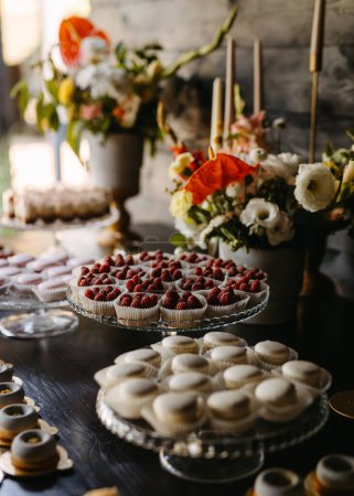 Photo for Dessert table at an event with macarons and tarts. Candy bar at a wedding. - Royalty Free Image
