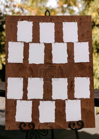 A rustic seating chart display with empty white cards on a wooden board.