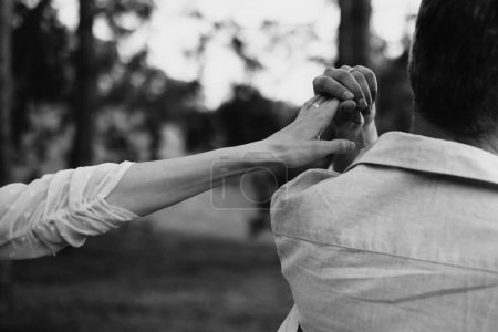 Téléchargez les photos : Une photographie en noir et blanc capture un moment de connexion : la main d'un homme saisit doucement celle d'une femme, symbolisant l'unité et le soutien. - en image libre de droit