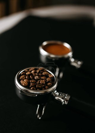 Téléchargez les photos : Deux portafiltres espresso sur une surface noire, l'un rempli de grains de café et l'autre de café moulu. - en image libre de droit