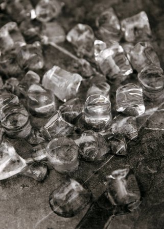Foto de Cubos de hielo dispersos sobre una superficie de mármol negro. - Imagen libre de derechos