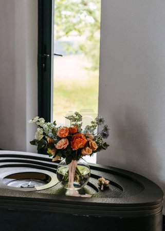 Photo for Floral arrangement in glass vase on table with ribbon, near window. - Royalty Free Image