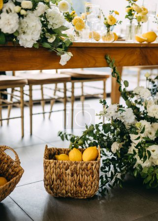 Foto de Elegancia rústica con limones en una cesta y flores blancas en flor. - Imagen libre de derechos