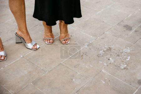 Foto de Vidrio roto en una fiesta en el suelo, junto a pies de mujer en zapatos. - Imagen libre de derechos