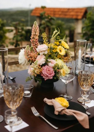 Photo for Rustic elegant wedding table setting with vibrant floral centerpiece. - Royalty Free Image