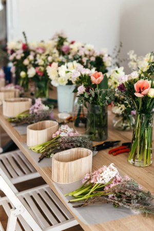 Foto de Arreglo floral espacio de trabajo con flores frescas cortadas. - Imagen libre de derechos