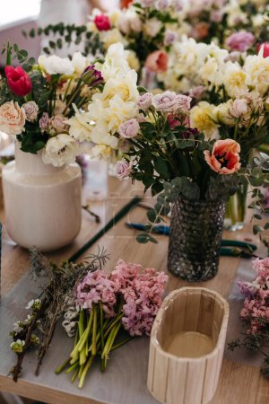 Photo for Fresh floral arrangement in the making at a floral workshop. - Royalty Free Image