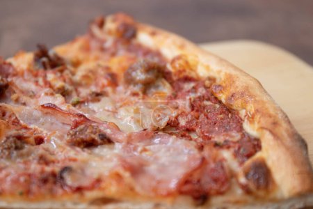 Leckeres italienisches Menü, ein Stück Fleisch-Liebhaber-Pizza auf weißem Untergrund