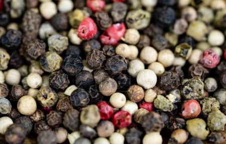 Photo for A stack of peppercorns on olive wood - Royalty Free Image