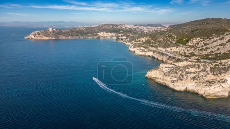 Téléchargez les photos : Vue aérienne avec drone de la Sella del Diavolo à Cagliari. Journée ensoleillée, mer cristalline avec bateaux. - en image libre de droit