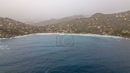 Windiger Tag an einem Strand auf Sardinien. Hohe Wellen voller Wasser. Bewölkt