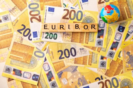 Das Wort EURIBOR steht in Holzbuchstaben auf dem Hintergrund von 200-Euro-Banknoten und Globus. Copy paste. Hochwertiges Foto