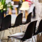 Black Plastic Chairs Are Arranged In Rows For Spectators Of Seminar At Exhibition. Blurred background. High quality photo