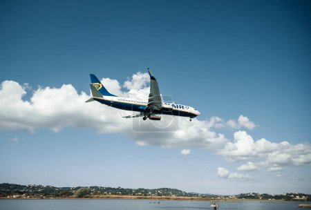 Foto de Kerkyra, Grecia - 09 24 2022: Ryanair avión está aterrizando en el aeropuerto de Corfú. El concepto de viajar a lugares separados e islas. Servicio aéreo entre el continente y la isla. Foto de alta calidad - Imagen libre de derechos