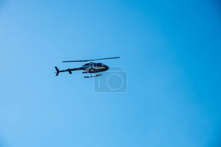 Foto de Kerkyra, Grecia - 09 24 2022: Helicóptero blanco y negro aterriza en el aeropuerto de Corfú. El concepto de controlar el vehículo de aire con Landin vertical. Foto de alta calidad - Imagen libre de derechos