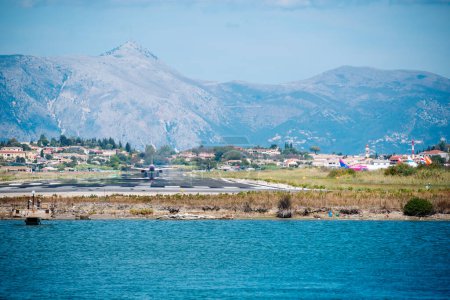 Foto de Kerkyra, Grecia - 09 24 2022: Aeropuerto de Corfú, Vista de la pista en la que el avión aterriza en el fondo de las montañas. Foto de alta calidad - Imagen libre de derechos
