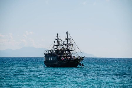 Photo for Kerkyra, Greece - 09 24 2022: At sea, a black tourist ship in the style of a pirate ship. High quality photo - Royalty Free Image