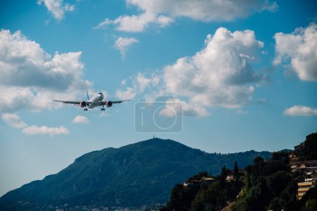 Foto de Kerkyra, Grecia - 09 24 2022: El avión de SAS Scandinavian Airlines aterriza en el aeropuerto de Corfú. En el fondo de la ciudad en las montañas y la pista en el agua. Foto de alta calidad - Imagen libre de derechos